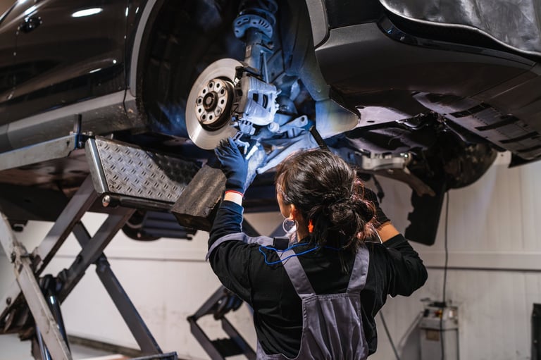 Female mechanic working under a car lifted on a hydraulic lift