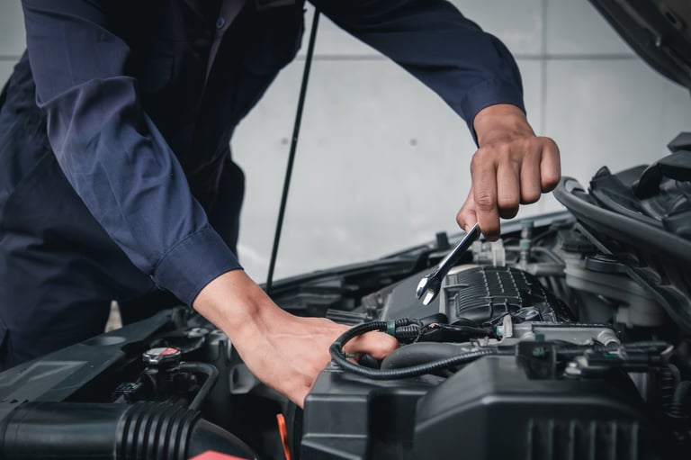 Mechanic using wrench while working on car engine